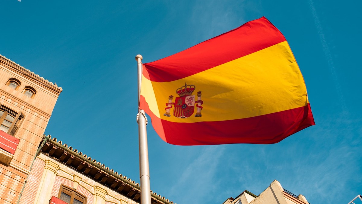 Bandera de España ondeando frente a un edificio