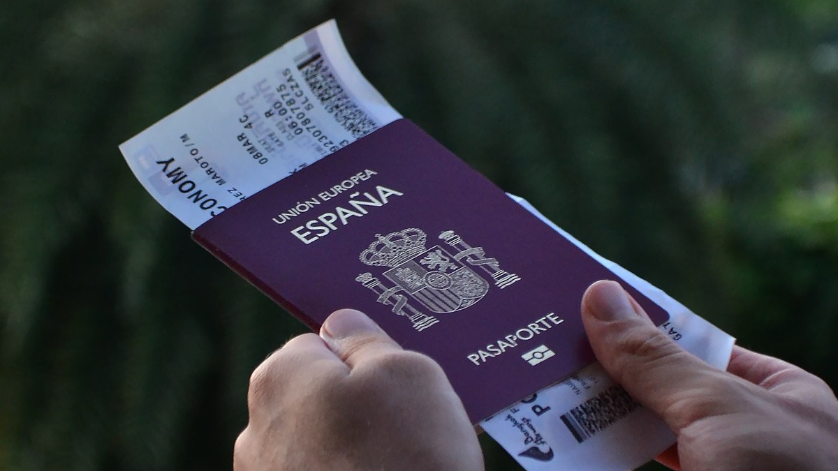 Pasaporte español sujeto con las manos